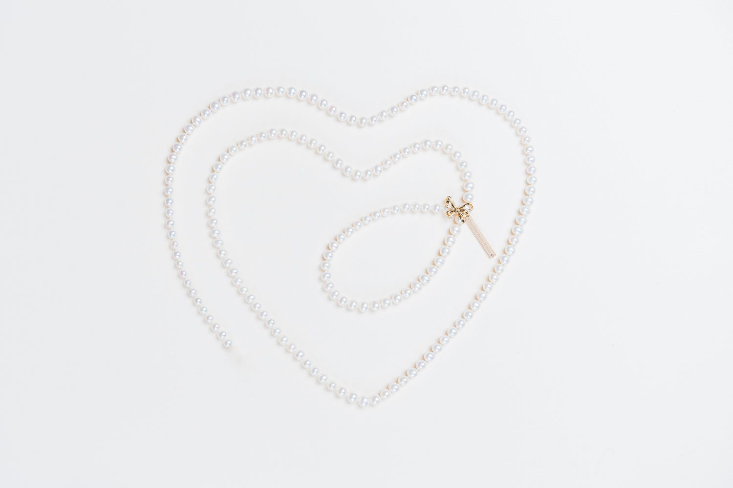 Akoya pearl necklace with diamond pave ribbon clasp