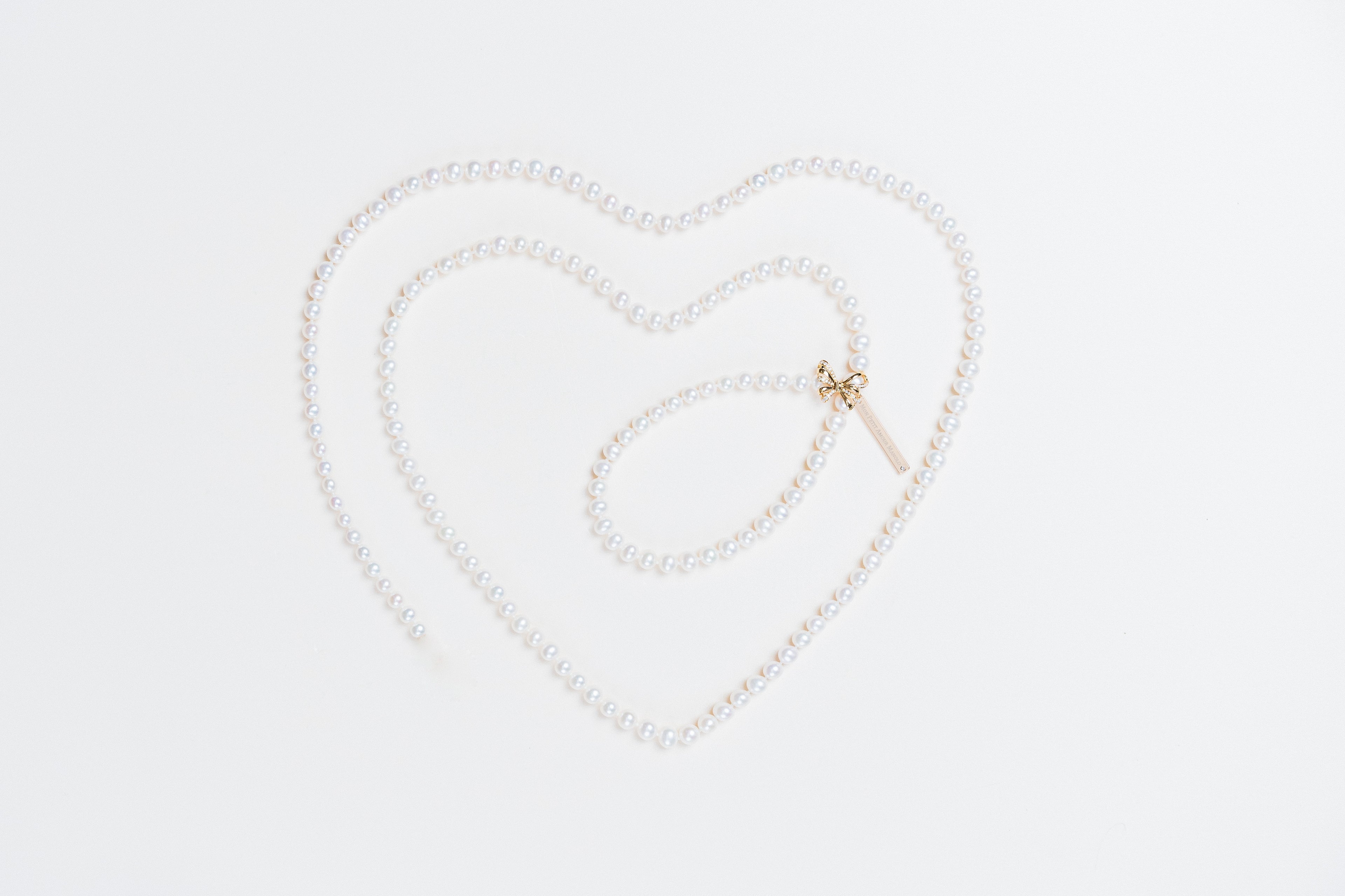 Akoya pearl necklace with diamond pave ribbon clasp